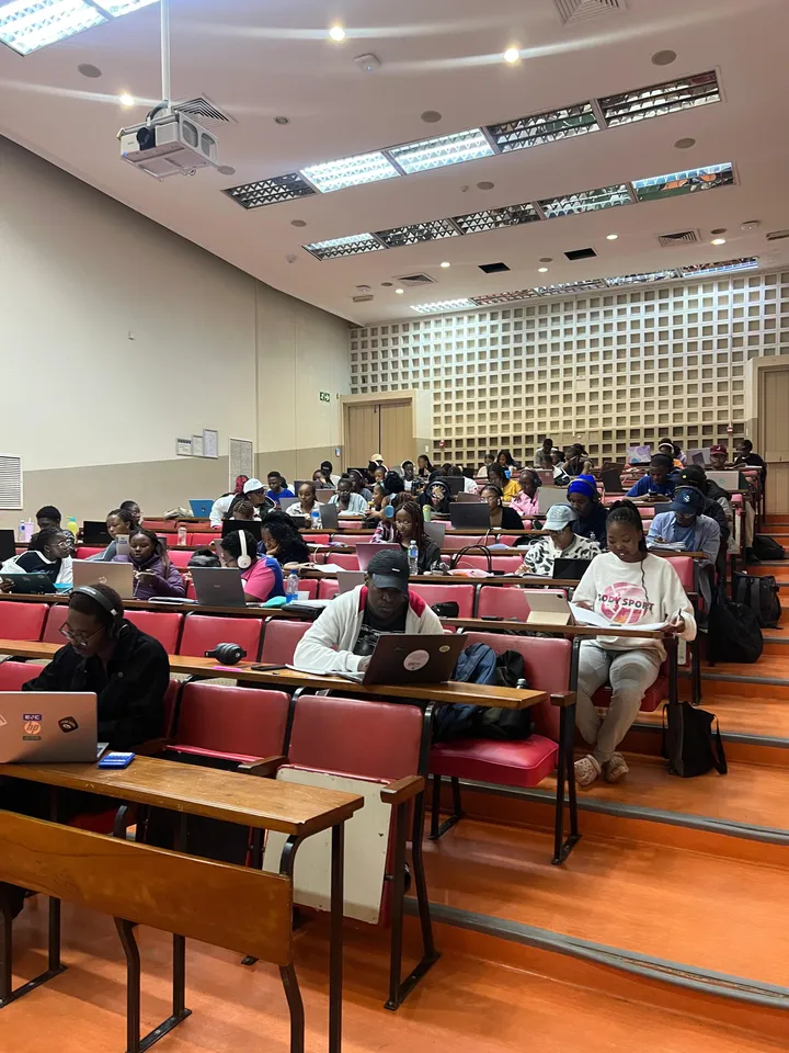 Students working on laptops through a lecture hall during an Edu Initiative study session