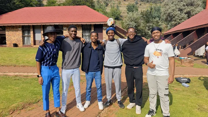 Six students from a Connect Group standing arm in arm outside on the grass